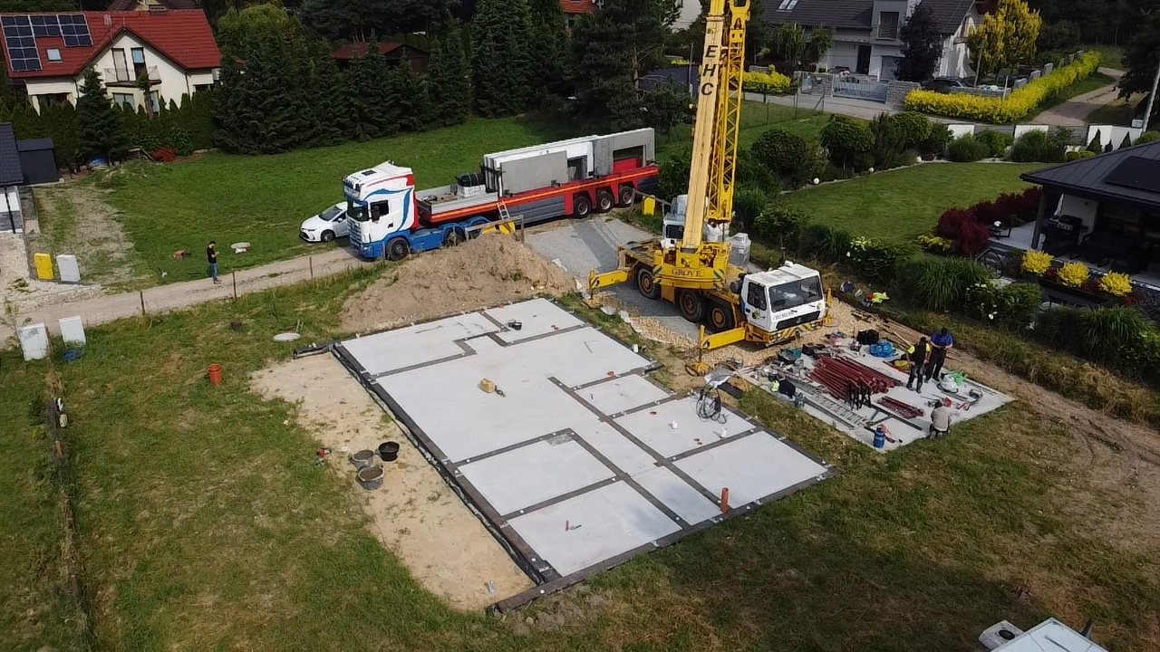 Dźwig i kilka płyt fundamentowych na budowie — realizacja Tulio pod Poznaniem